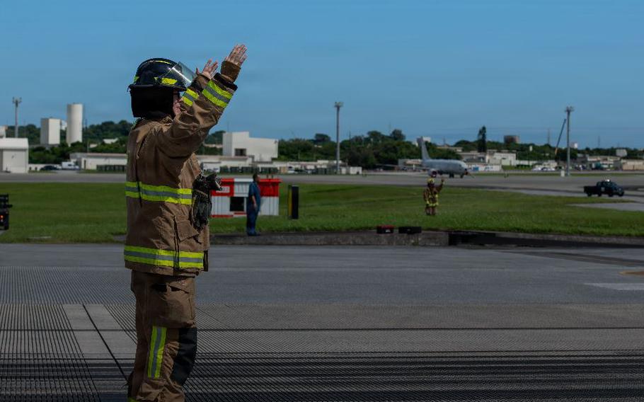 U.S. Air Force Senior Airman Luke Yates, 18th Civil Engineer Squadron driver operator, coordinates a rewind operation after an aircraft arresting system certification at Kadena Air Base, Japan.